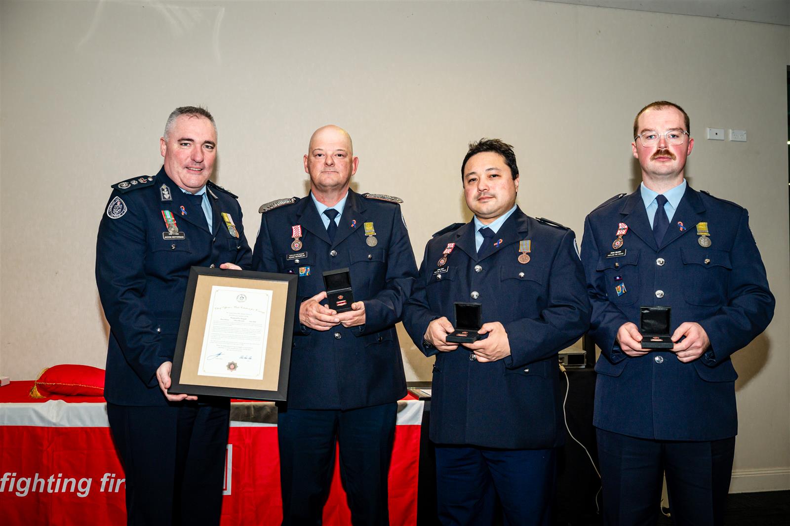 Chief Officer Jason Heffernan presenting the Unit Citation for Courage to Adam Hermelin, John Wolf and Ryan Delong